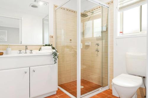 a bathroom with a shower and a toilet and a sink at 'Sanctuary On Walmer' - Sanctuary Point NSW in Sanctuary Point