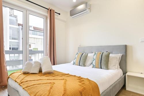 een slaapkamer met een groot bed en een raam bij Sé Apartamentos - Largo da Estação Apartments in Braga