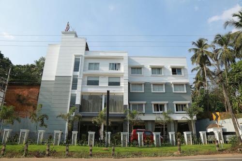 a white building with a statue on top of it at HOTEL SKY PARADISE in Iritti