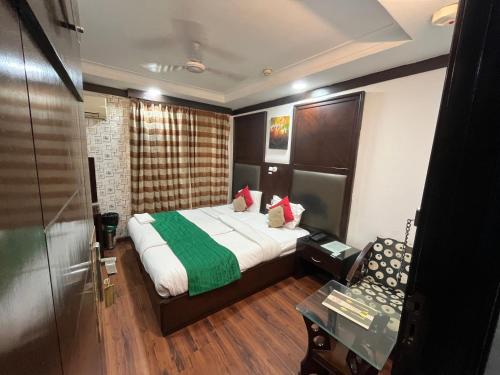 ein Hotelzimmer mit einem Bett und einem Stuhl in der Unterkunft corporate stay in Neu-Delhi