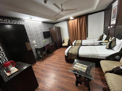 een hotelkamer met 2 bedden en een bank bij corporate stay in New Delhi