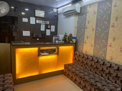 a restaurant with a yellow counter and a bench at corporate stay in New Delhi