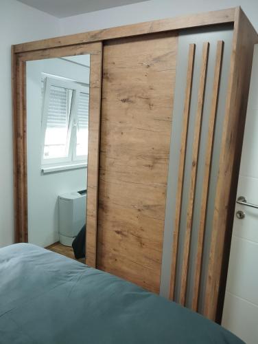 a wooden door in a bedroom with a bed at Stan na dan Bijeljina Niki 2 in Bijeljina