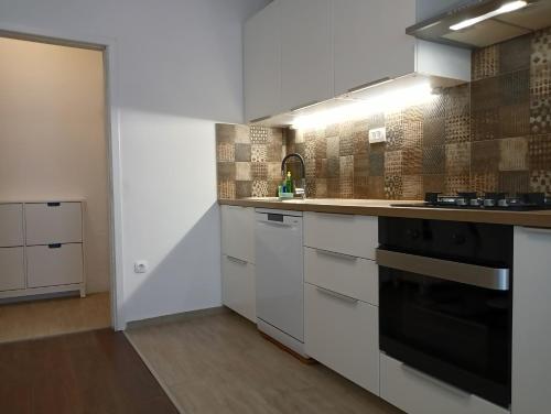 uma cozinha com armários brancos e um fogão preto em Apartment Lungomare em Umag