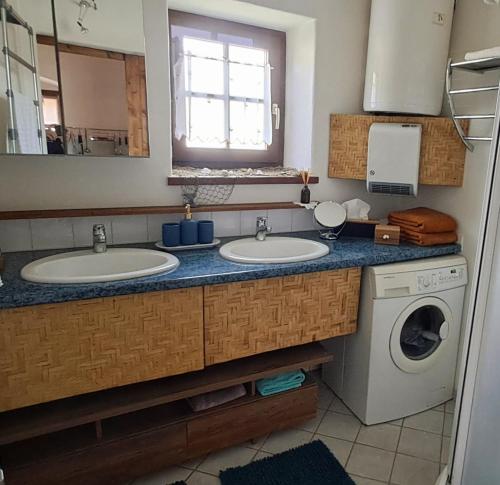 uma casa de banho com 2 lavatórios e uma máquina de lavar roupa em Gemütlichkeit am Vierkanthof - Apartment 1 em Wörterberg