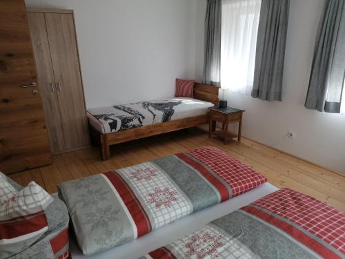 a bedroom with two beds in a room with a window at Berghaus Martin in Neustift im Stubaital