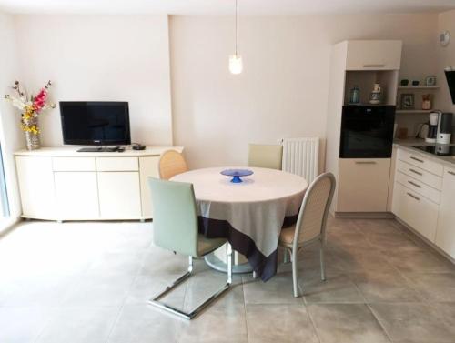 une cuisine avec une table et des chaises dans une pièce dans l'établissement Appartement Les Flots d Arthlotte Cabellou Plage, à Concarneau