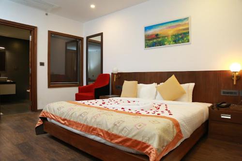 a bedroom with a large bed with a red chair at HOTEL SKY PARADISE in Iritti