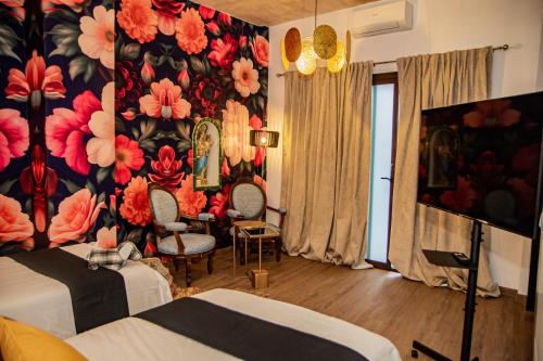 une chambre d'hôtel avec un mur floral dans l'établissement Casa Señorial Piedrachica, à Séville