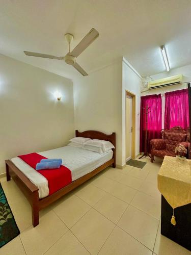 a bedroom with a bed and a ceiling fan at Normanis Homestay in Kota Bharu