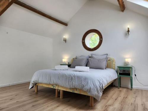 ein Schlafzimmer mit einem großen Bett und einem Spiegel an der Wand in der Unterkunft les maisons de Jean et Eva in Nalliers