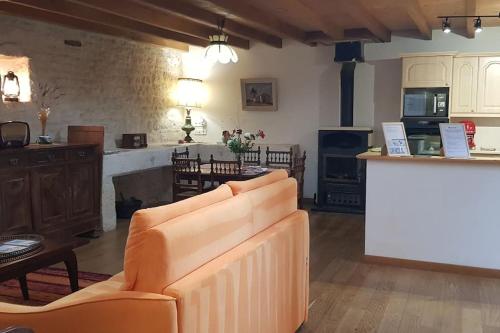 un salon avec un canapé et une cuisine dans l'établissement les maisons de Jean et Eva 5 chambres, à Nalliers