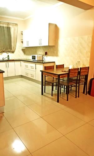 a kitchen with a dining room table and chairs at BEST APARTMENTS in Mbabane
