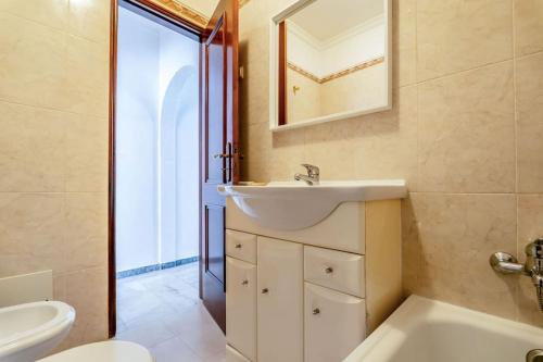 a bathroom with a sink and a tub and a toilet at Perfect house close to beach in Armação de Pêra