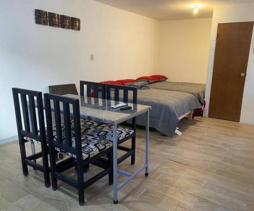 a room with a table and two chairs and a bed at Bonito departamento tipo “estudio” 2 in Ciudad Juárez