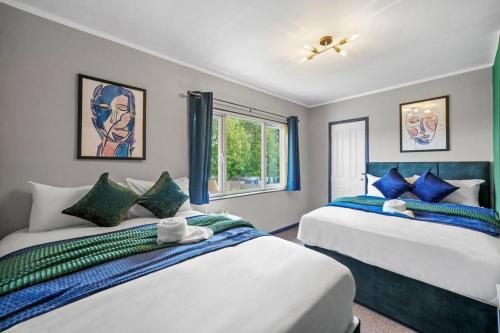 1 dormitorio con 2 camas y ventana en Spacious Luxury Garden House Free Parking, en Bristol