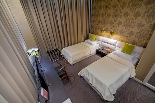a hotel room with two beds and a table at La Bohème Hotel in Tirana