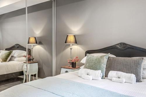 a bedroom with two beds and a mirror at Hidden Gem on Loftus in Wollongong