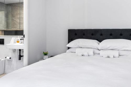 a bedroom with a white bed with white pillows at Scenic Wollongong Gem - City Location with Rooftop in Wollongong