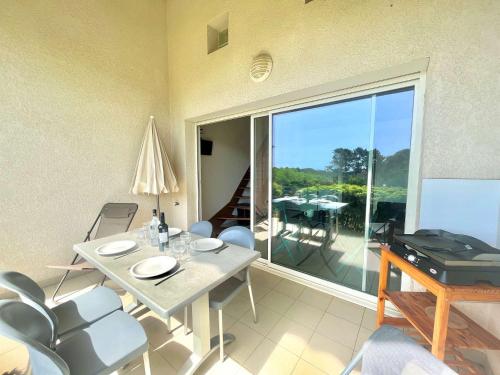 un salon avec une table et des chaises et un balcon dans l'établissement Appartement Bella Vista 302 Porticcio, à Porticcio