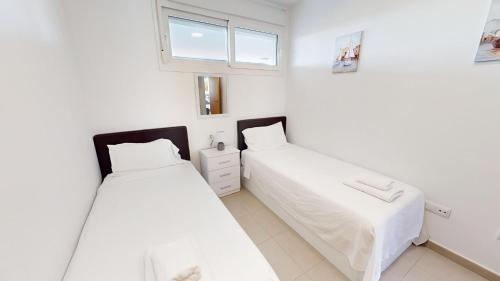2 camas en una habitación blanca con ventana en Casa Principe L - Murcia Holiday Rentals Property en Roldán