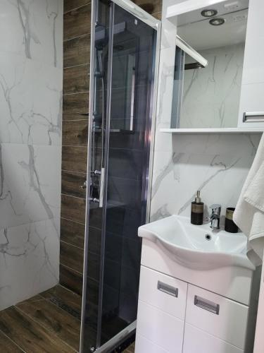a bathroom with a shower and a sink at Apartman J72 in Ostrovo