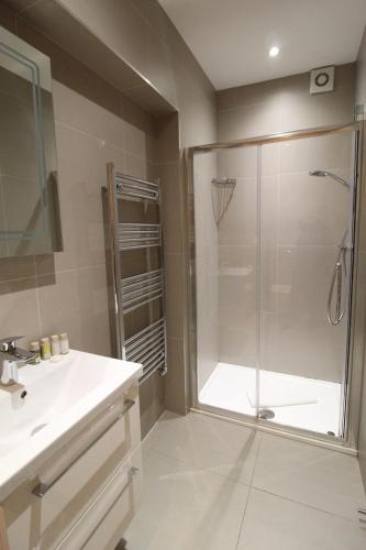 a bathroom with a shower and a sink at West Finchley by Viridian Apartments in Finchley
