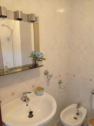 een badkamer met een wastafel en een spiegel bij Acogedor apartamento céntrico in O Grove
