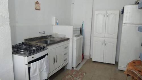a kitchen with a stove and a sink and a refrigerator at Casinha Aconchegante in Guarulhos