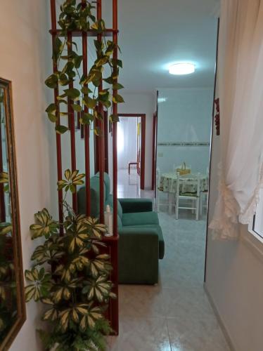 een woonkamer met een groene bank en een spiegel bij Acogedor apartamento céntrico in O Grove