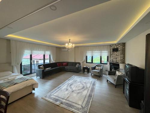Fuays Villa Premium في طرابزون: غرفة معيشة كبيرة مع سرير وأريكة