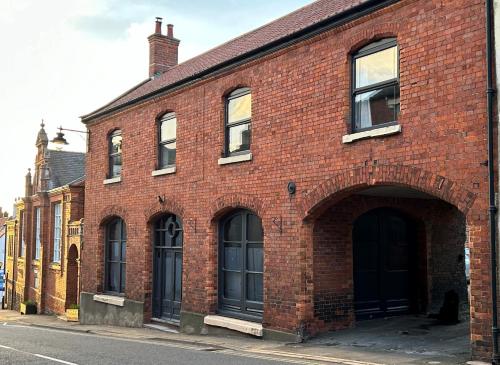 a red brick building with an archway on a street at Caistor Bed & Breakfast in Caistor