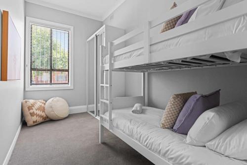 a bedroom with two bunk beds and a couch at Haven on Hunter - 500m to Civic Theatre in Newcastle