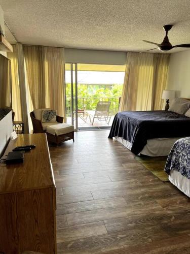 a bedroom with a bed and a living room with at IslandVista 1BR: Ocean & Golf Bliss in Kahana