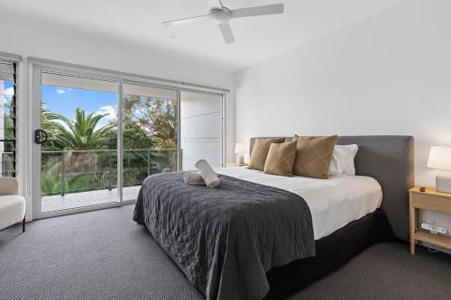a bedroom with a large bed and a large window at Catch the Breeze - Pet Friendly Townhouse in Newcastle