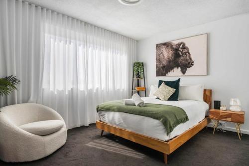 a bedroom with a bed and a chair at Seascape - 500m to Merewether Ocean baths in Merewether