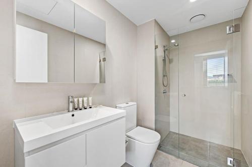 a bathroom with a sink and a toilet and a shower at Harbour-View Luxury - Herald Building Newcastle in Newcastle