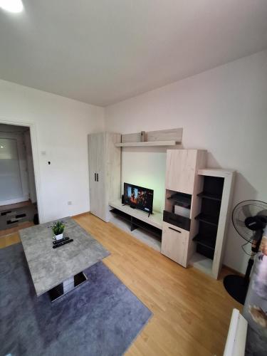 un salon vide avec une table et une télévision dans l'établissement Apartman, à Brčko