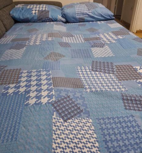 - un lit avec une couette bleue et blanche dans l'établissement Apartman, à Brčko