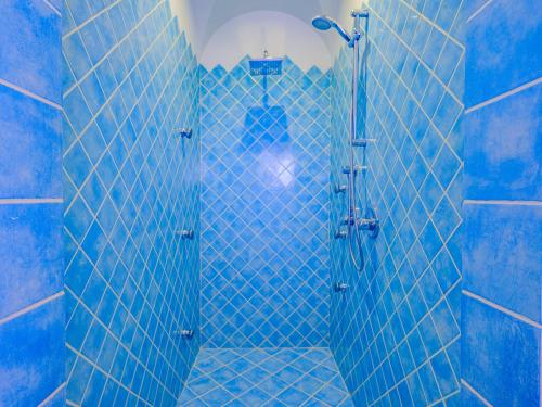a blue tiled shower with a glass door at Sardinia Family Villas - Villa Brunilde with private pool in Arzachena