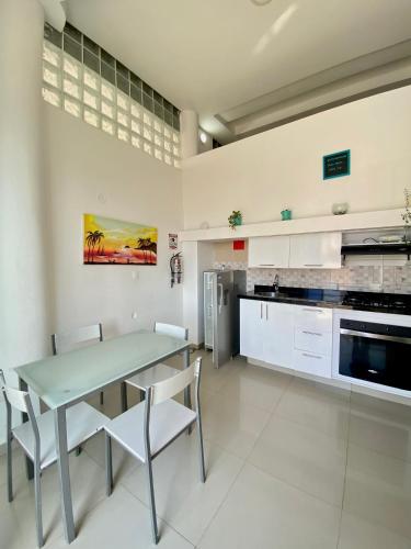 a kitchen with a table and chairs in a room at Hotel Cabañas Villa Roca, Rodadero in Santa Marta