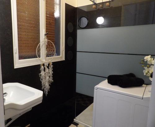 La salle de bains est pourvue d'un lavabo et de toilettes blanches. dans l'établissement Studio japonisant, à Nice