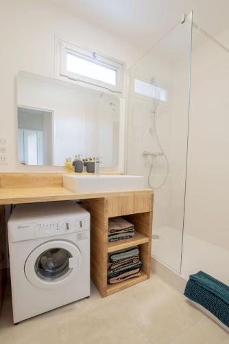 La salle de bains est pourvue d'un lave-linge et d'un miroir. dans l'établissement Rêve - Appartement Terrasse Vue Mer, à Concarneau