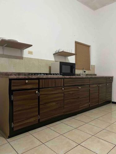 uma grande cozinha com armários de madeira e uma bancada em Bonito departamento tipo “estudio” em Ciudad Juárez