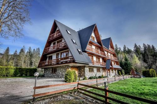 a large house with a black roof at U Króla in Kościelisko