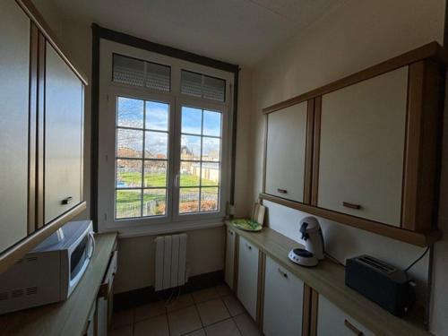 - une cuisine avec un évier et un four micro-ondes ainsi que 2 fenêtres dans l'établissement Berck Plage appartement 5 personnes, à Berck-sur-Mer