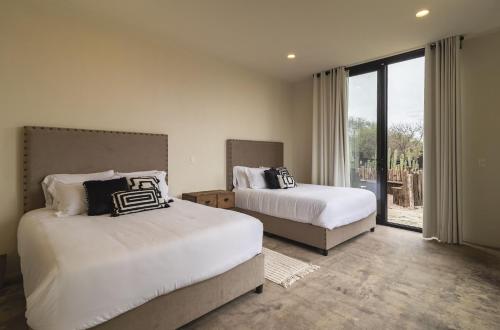 1 Schlafzimmer mit 2 Betten und einem großen Fenster in der Unterkunft Increible Casa Con Vista Panoramica A La Presa in San Miguel de Allende