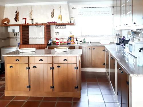 una cucina con armadi in legno e piano di lavoro di 3 bedrooms house with furnished garden and wifi at Encarnacao 1 km away from the beach a Encarnação