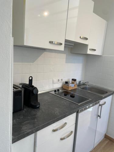 a kitchen with white cabinets and a sink and a stove at Apartment in Velden am Wörthersee, Top 3 in Velden am Wörthersee