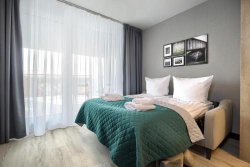 a bedroom with a bed with a green blanket at AboutArtApartments - Otyńska 4 in Wrocław